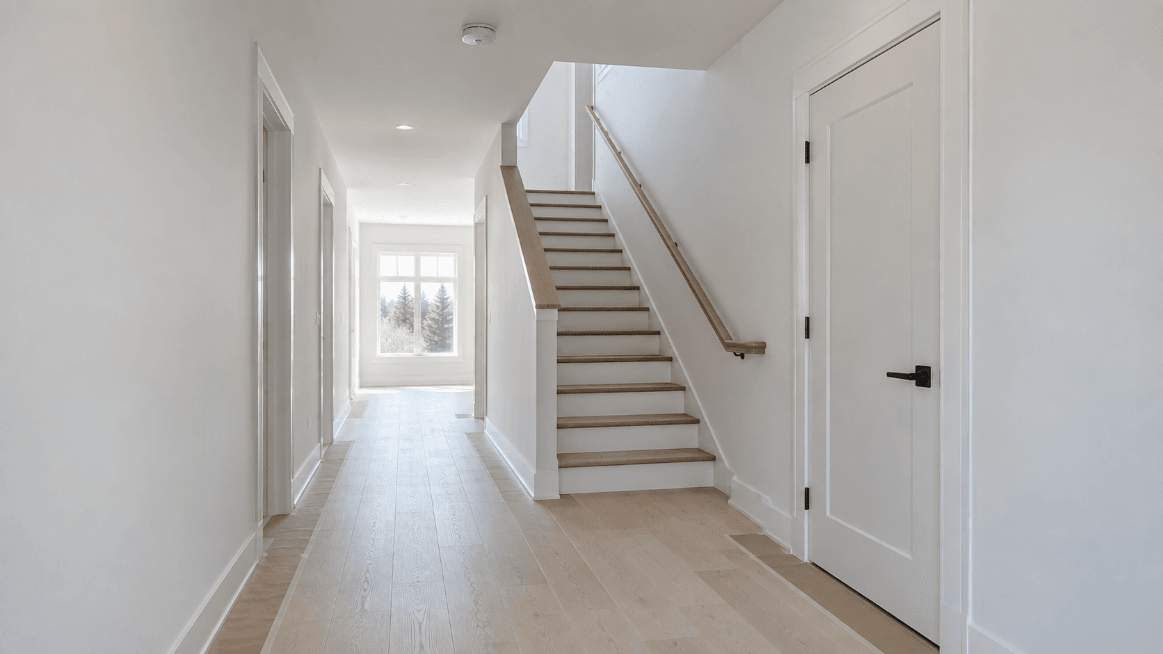 Completed interior with finished stairs, handrail and smoke alarm visible before occupancy